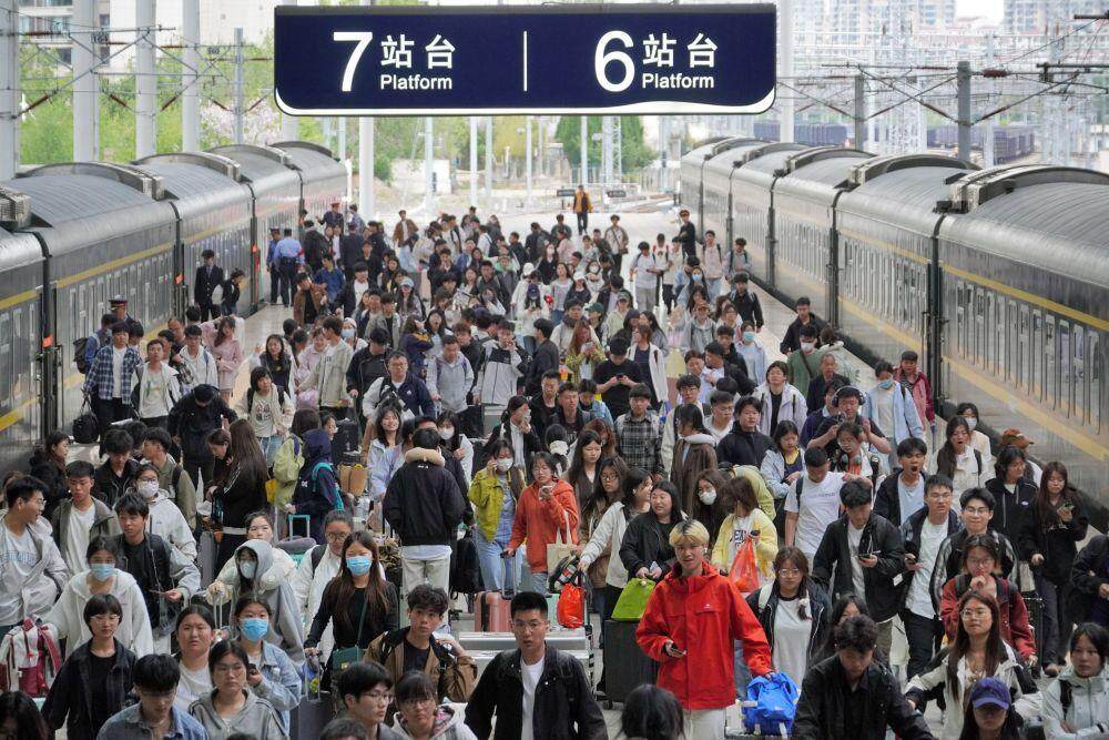 5月5日，旅客在山东烟台站下车出站。新华社发（唐克 摄）