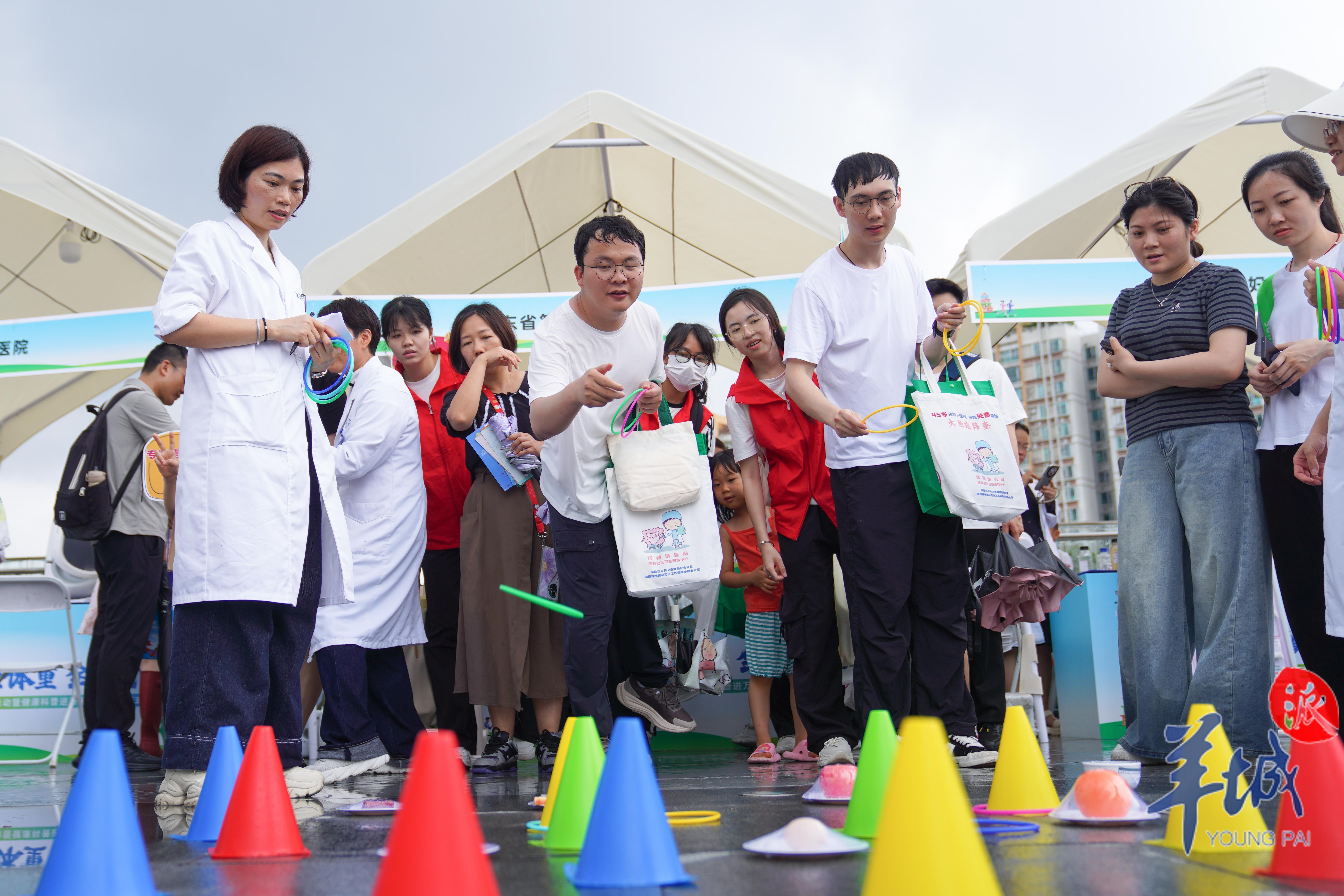 活动现场，市民排队参与套圈游戏环节