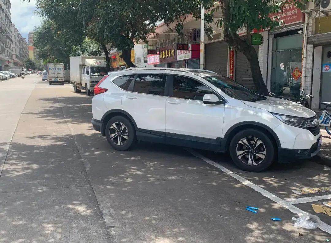 蓬江区某路段，停车秩序混乱，有车辆斜插进车位停车。图/记者陈卓栋摄