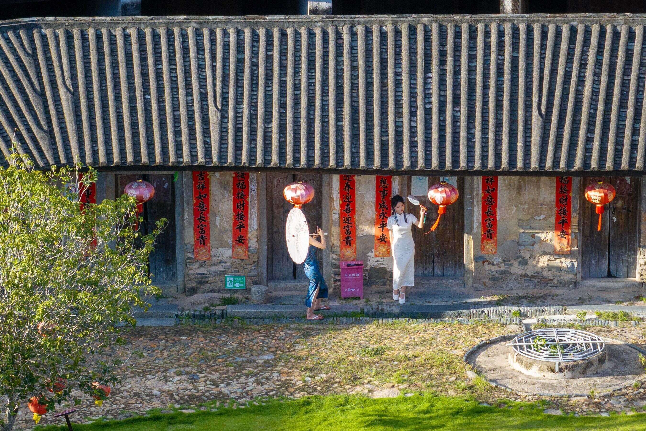 身穿旗袍的游客在道韵楼里拍照