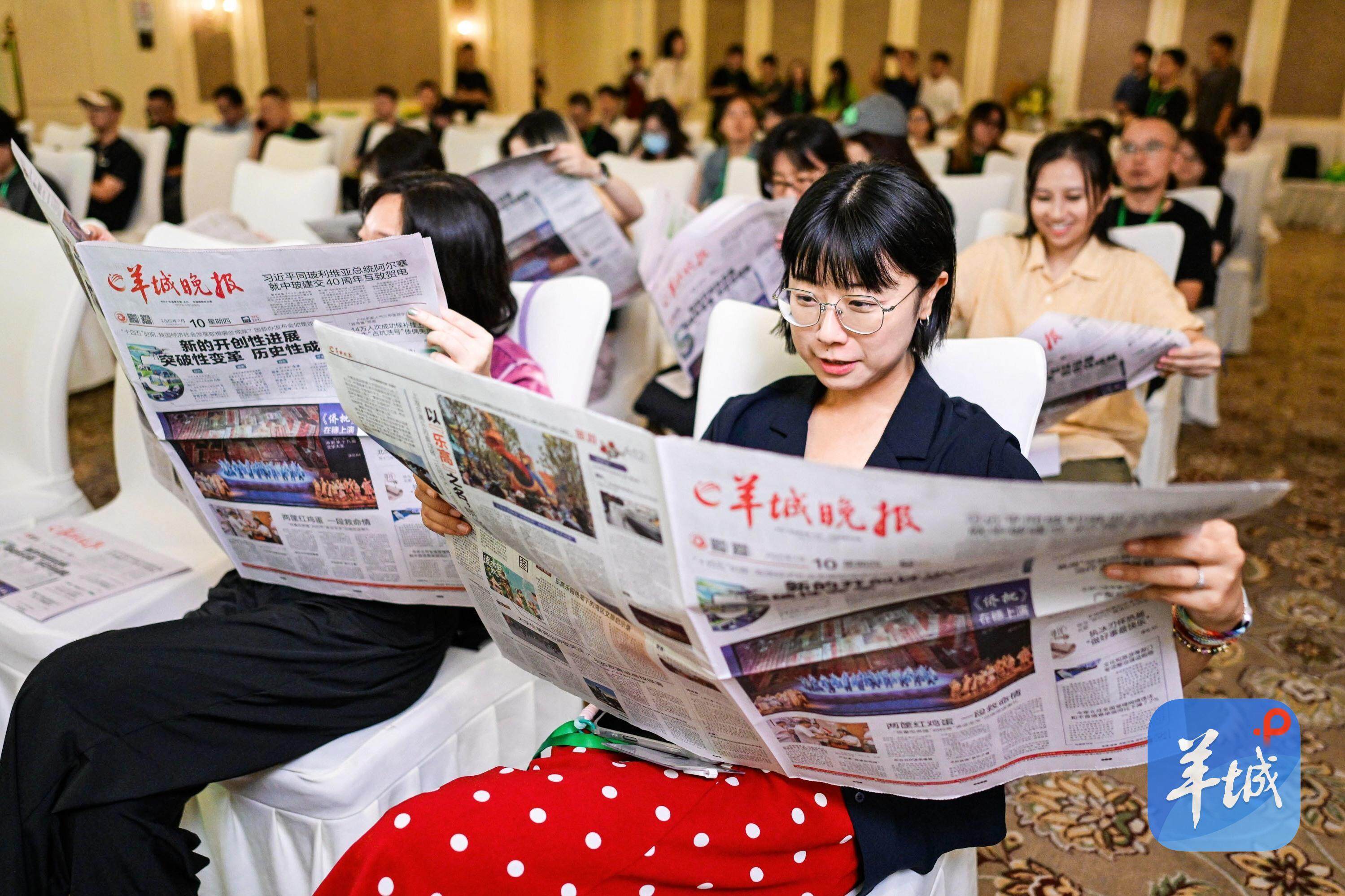  现场嘉宾在羊城晚报上查看活动即时报道