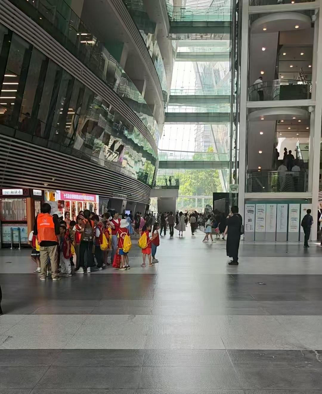  一个来自清远的研学团刚好参观完图书馆，正在整队准备离开，几十个孩子互相嬉闹