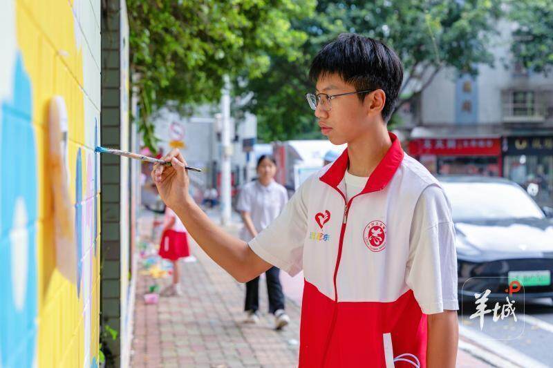 学生志愿者地完成墙绘