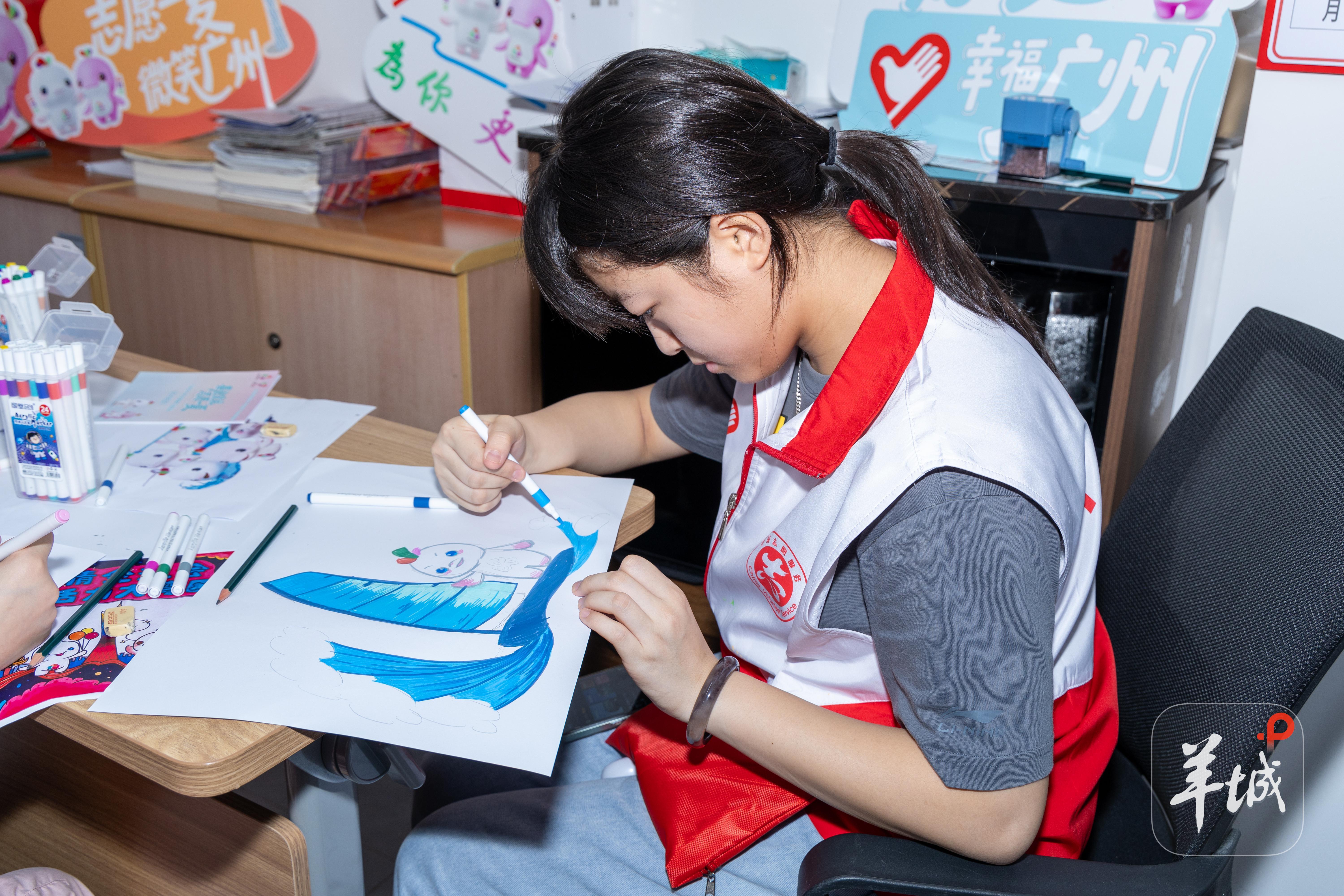 中小学生志愿者专注绘制十五运会帆船项目主题画作