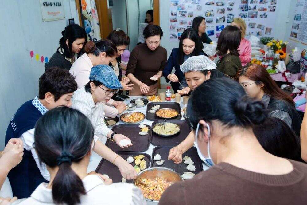 协会代表们与受助家庭一起挽起袖子，携手包饺子