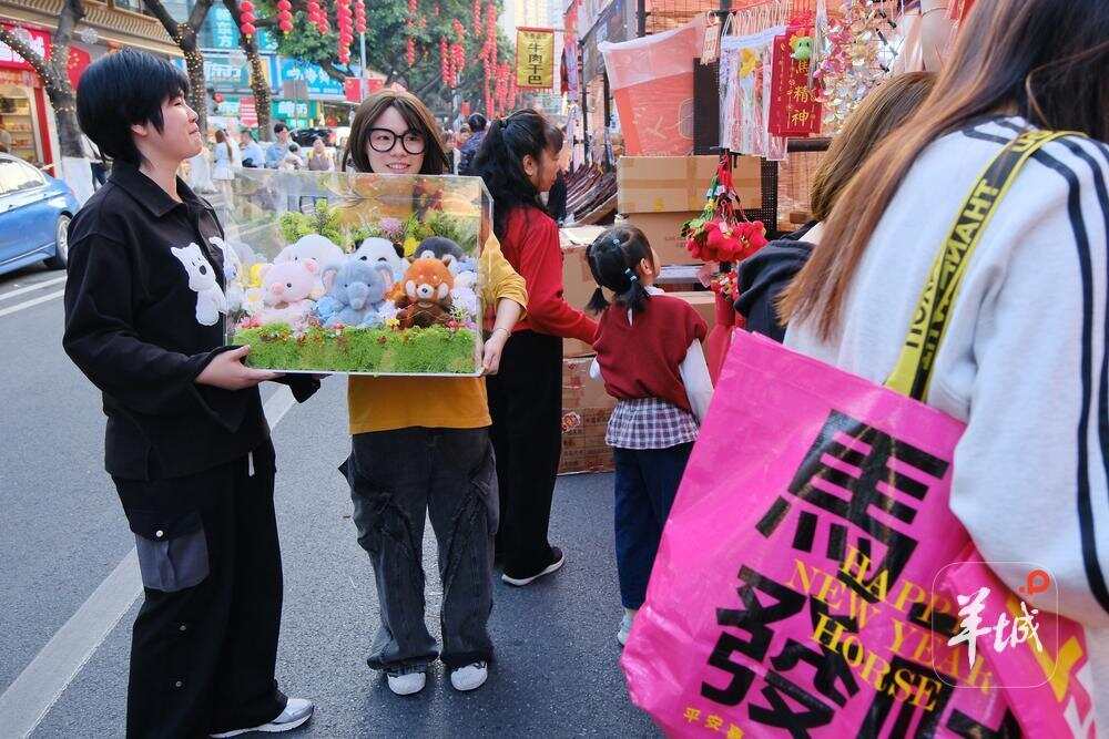  不少街坊一早过来行花街，买买买，笑开颜