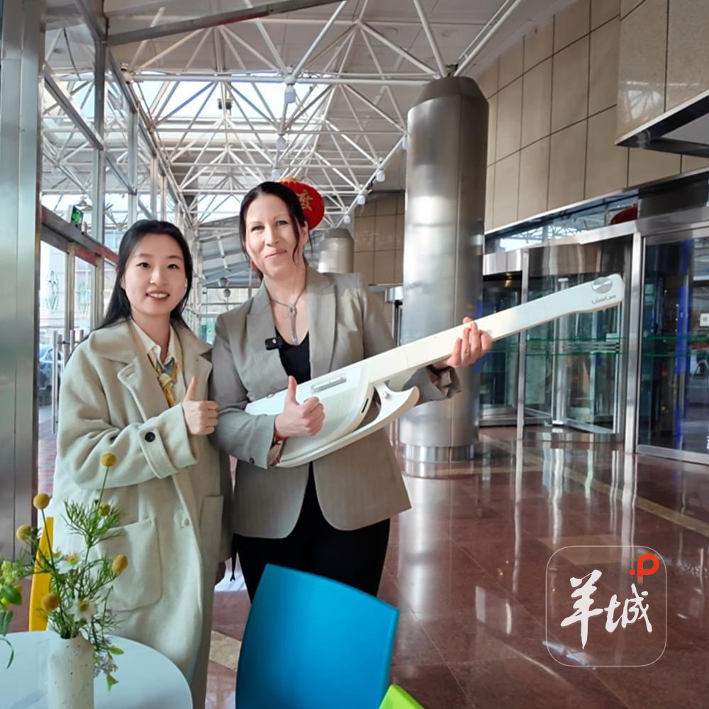 记者刘泳希代品牌方将吉他送给赫列娜。羊城晚报记者 温泽广 摄