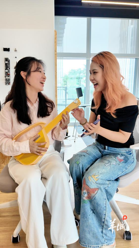 记者刘泳希与Liberlive产品经理李嘉欣一起弹琴。羊城晚报记者 温泽广 摄