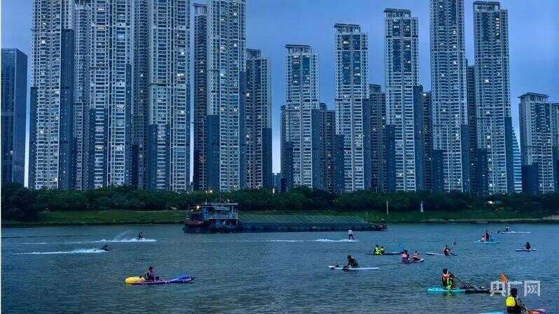 五颜六色的桨板、机动冲浪板铺满近岸江面，其中不少划入主航道