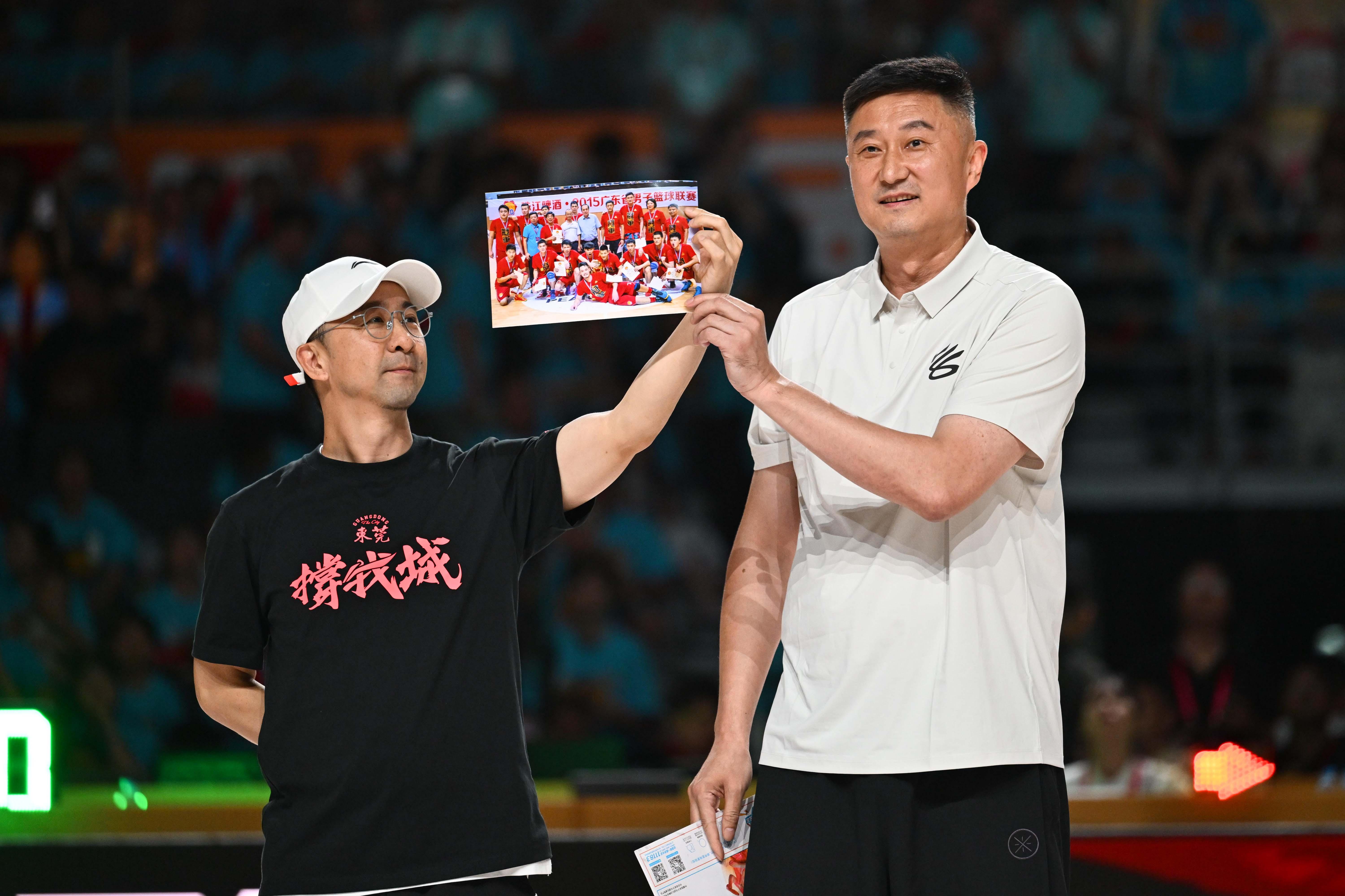 广东省篮协会长杜锋向球迷展示东莞队昔日夺冠老照片